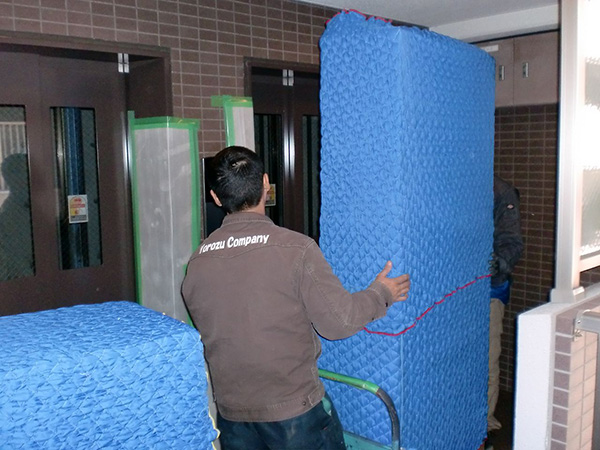 大きな食器棚の処分は、キズ防止パッドで包んで運び出します。