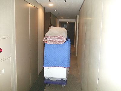 通路の狭いマンションなどは洗濯機をパッドで包み建物にキズが付かないように運び出します。